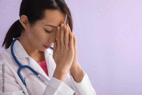 Female Asian doctor praying...