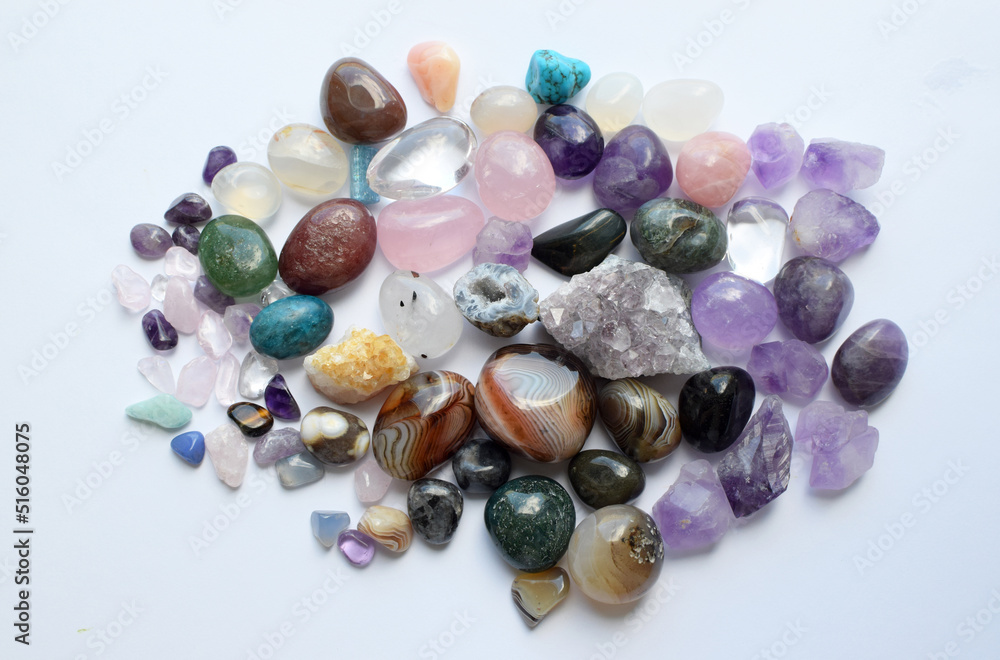 Tumbled gems of various colors. Amethyst, rose quartz, agate, apatite, aventurine, olivine, turquoise, aquamarine, rock crystal on white background. Tumbled gems of various colors. Amethyst, rose quartz, agate, apatite, aventurine, olivine, turquoise, aquamarine, rock crystal on white background.