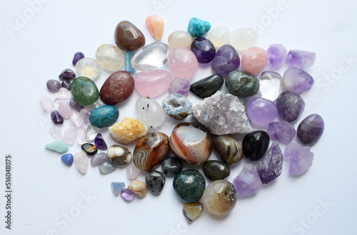 Tumbled gems of various colors. Amethyst, rose quartz, agate, apatite, aventurine, olivine, turquoise, aquamarine, rock crystal on white background.