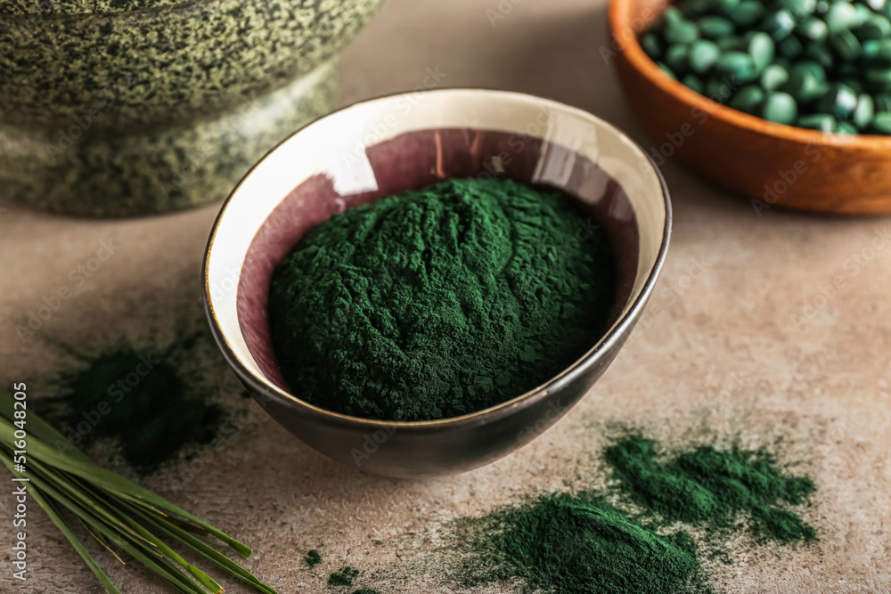 Bowl of spirulina powder on grunge background, closeup Bowl of spirulina powder on grunge background, closeup