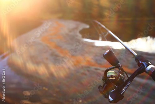 spinning reel in hand fishing nature, abstract background, hobby vacation man
