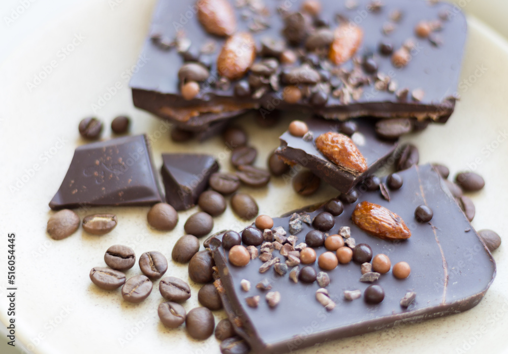 Chopped dark chocolate with almond and coffee beans. Broken chocolate on beige plate. Sweet food. Dark chocolate iwith nuts. Coffee product. Chopped dark chocolate with almond and coffee beans. Broken chocolate on beige plate. Sweet food. Dark chocolate iwith nuts. Coffee product.