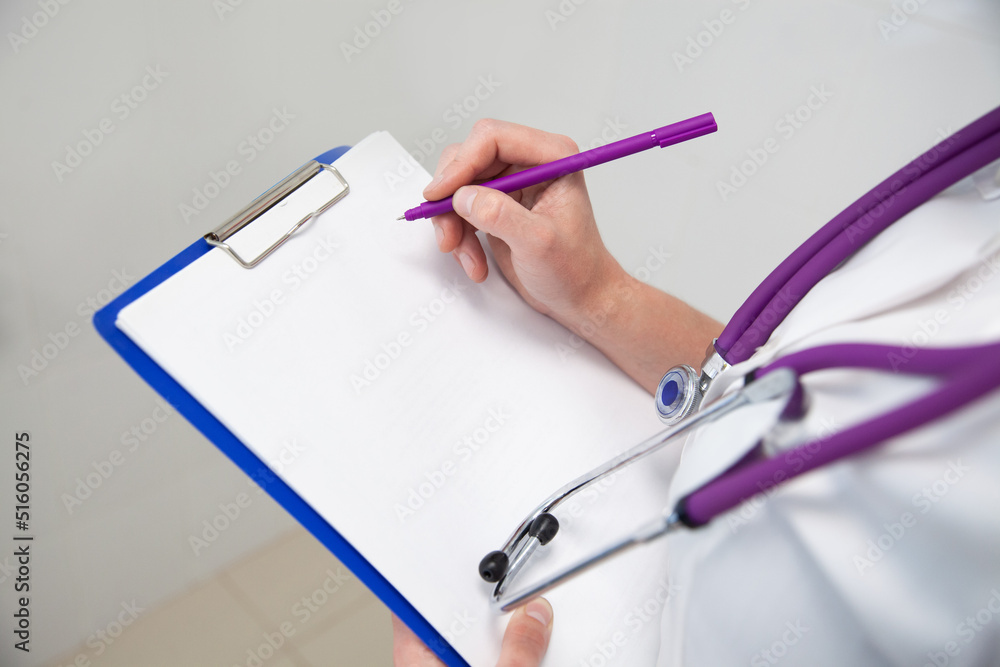 Folder, clipboard with white blank paper sheet in female doctor hands. Purple pen in hand and stethoscope on chest. Copy space Folder, clipboard with white blank paper sheet in female doctor hands. Purple pen in hand and stethoscope on chest. Copy space