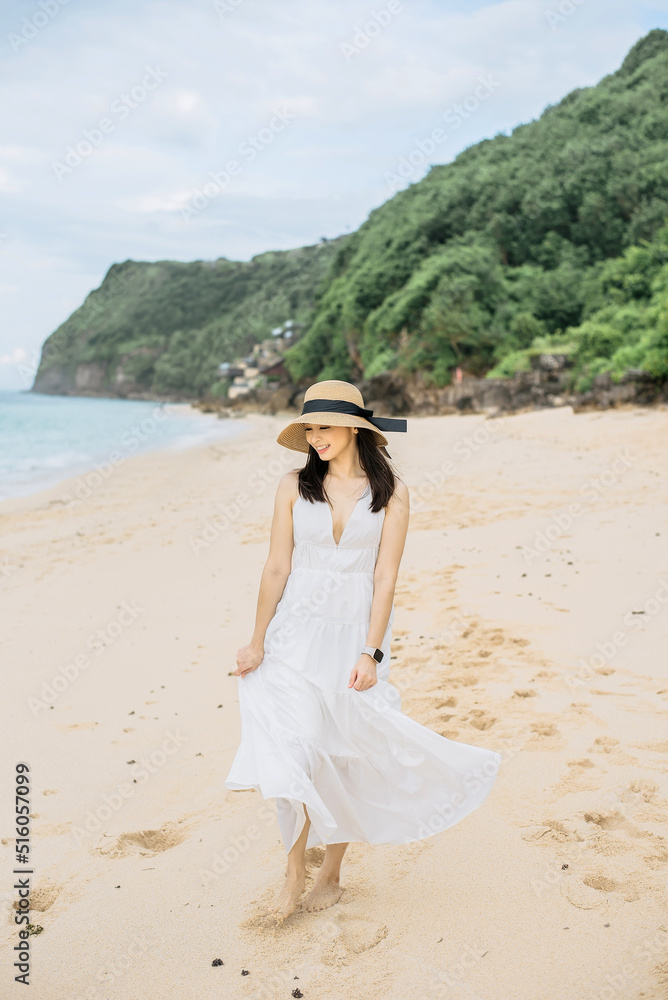 an asian woman is walking along the coast on the beach an asian woman is walking along the coast on the beach