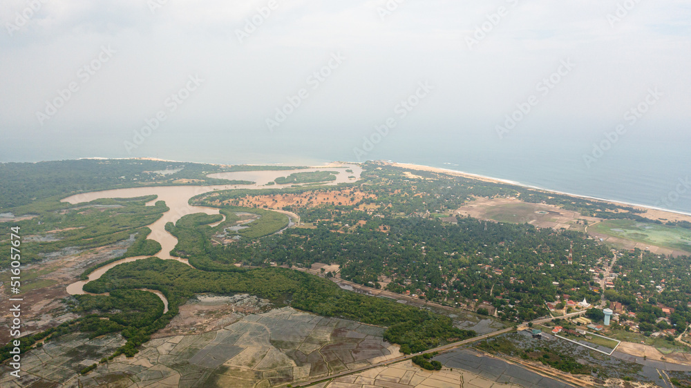 Top view of small town among agricultural lands near the ocean. Sri Lanka.