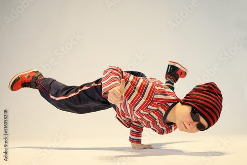 boy in breakdance position, boy stands on one hand, unique dance pose