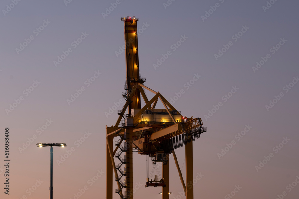 A large harbor crane against a vivid sky during the sunset A large harbor crane against a vivid sky during the sunset