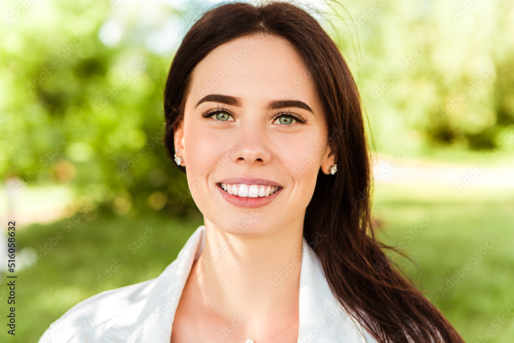 Close up head portrait of smiling caucasian woman with white teeth looking at the camera. Perfect healthy smile with veneer. Skin and dental care. Nature green background.
Close up head portrait of smiling caucasian woman with white teeth looking at the camera. Perfect healthy smile with veneer. Skin and dental care. Nature green background.
