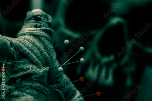 curse doll in hand and skull background