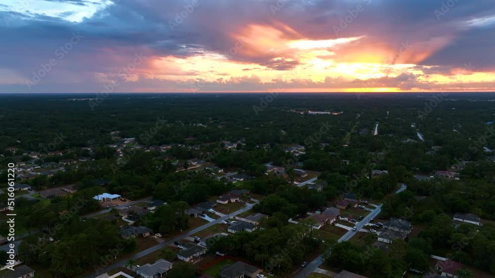 Aerial view of suburban landscape with private homes between green palm trees in Florida quiet residential area in evening Aerial view of suburban landscape with private homes between green palm trees in Florida quiet residential area in evening