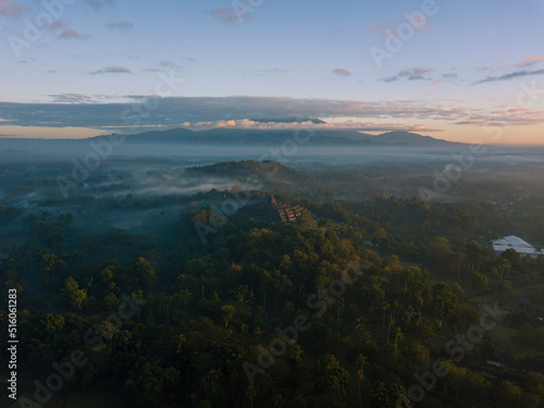 Magnificent Borobudur temple aerial shot in the sunrise time with mountain on the background. Java, Indonesia