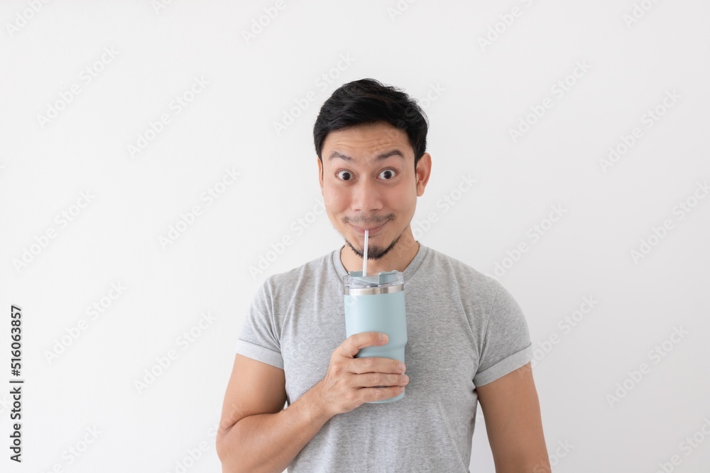 Happy asian man has cold drink from thermos mug isolated on white background. Happy asian man has cold drink from thermos mug isolated on white background.
