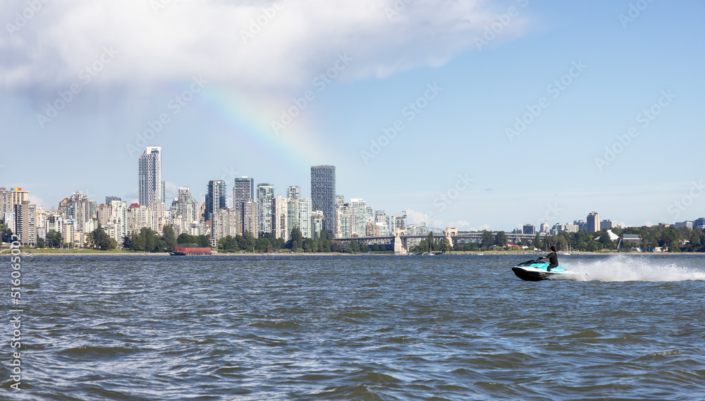 Obraz premium Adventurous Caucasian Woman on Water Scooter riding in the Ocean. Modern City in background. Downtown Vancouver, British Columbia, Canada. Colorful Rainbow