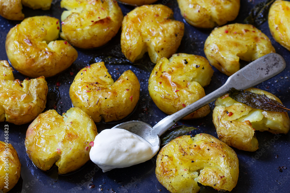Broken potatoes baked in oil with herbs and sauce.