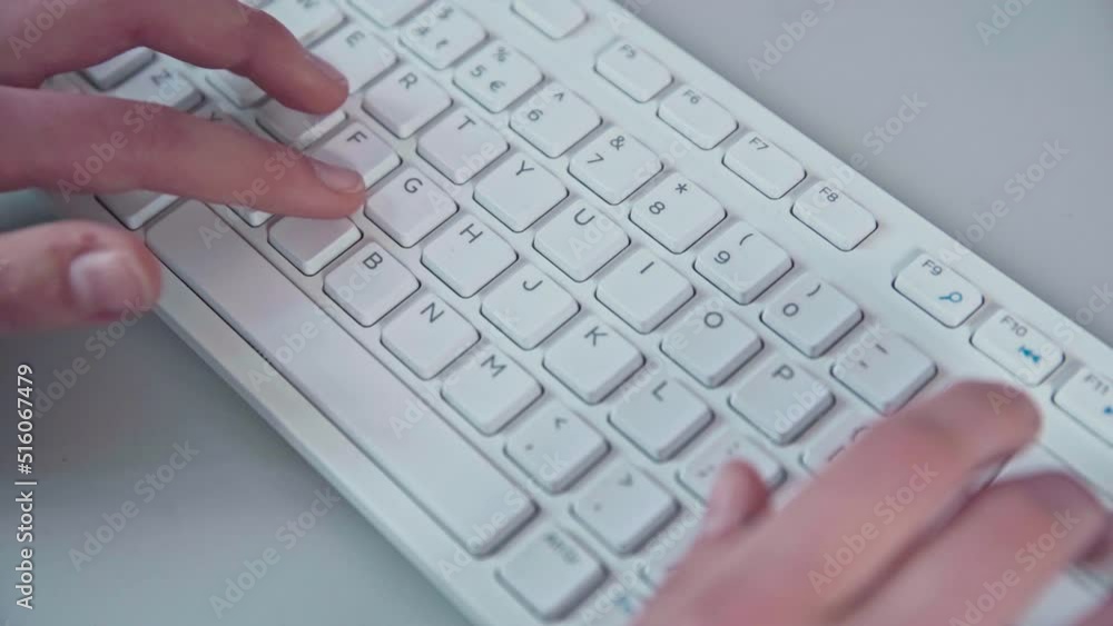 Young female hands operate a white computer keyboard. Top view. Young female hands operate a white computer keyboard. Top view.