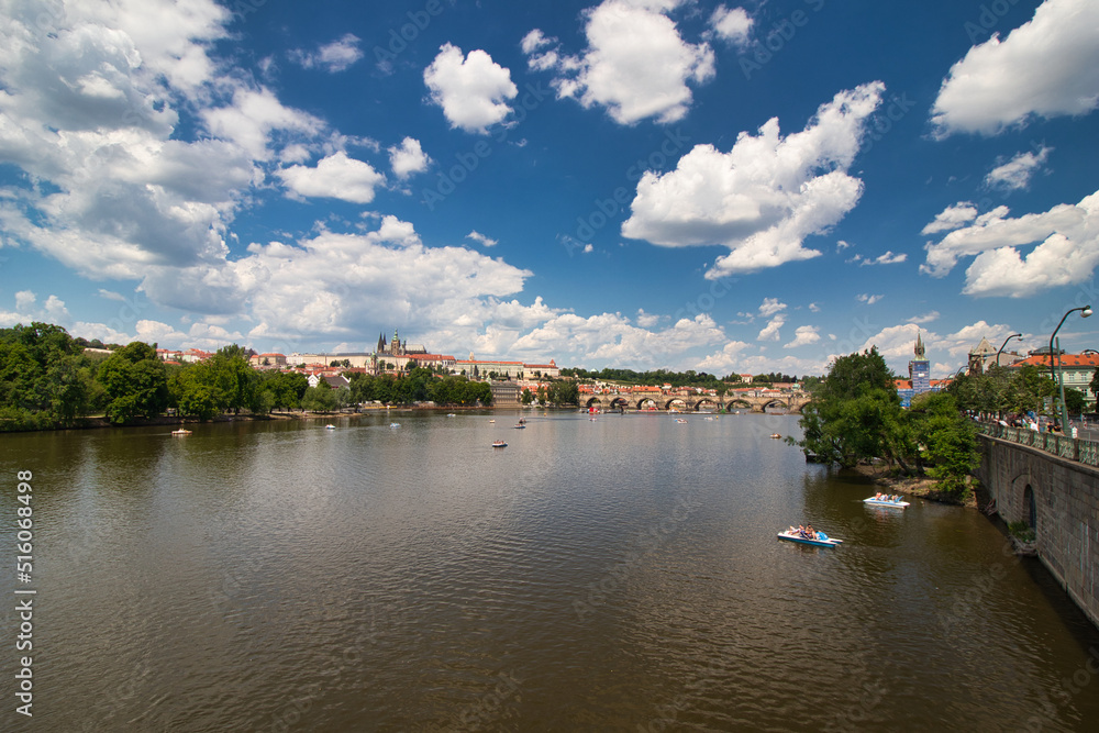 Pedal boat on Vltava river ,Charles bridge and Prague Castle in background.