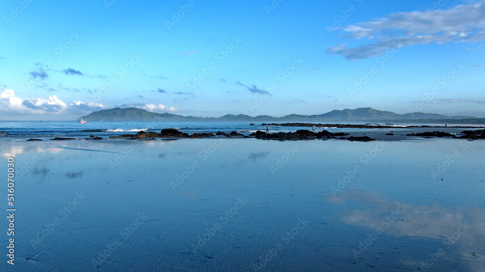 Sunrise on the beach in Tamarindo, Costa Rica, with mountains in the distance