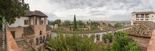 Panoramic view at the Garden Water Channel, or Patio de la Acequia, Generalife Gardens, Alhambra citadel as background, Granada, Spain photo