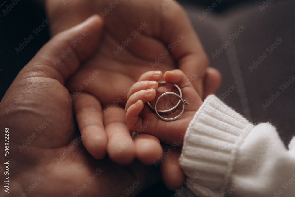 family concept wedding rings in hands wedding rings in the hands of a newborn baby. Stock Photo Adobe Stock