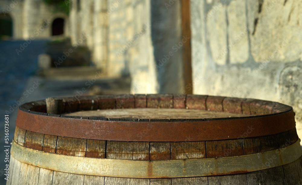 Old, rustic wine barrel outdoor in front of wine cellar