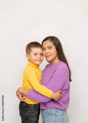 Happy young mother with her little son on a white background. The concept of a happy family, motherhood. portrait mom and baby