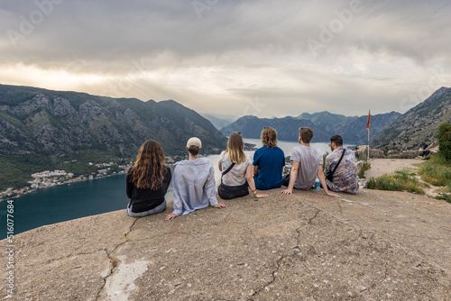 grupo de pessoas contemplando o pôr do sol com vista para montanhas em Kotor, Montenegro. photo