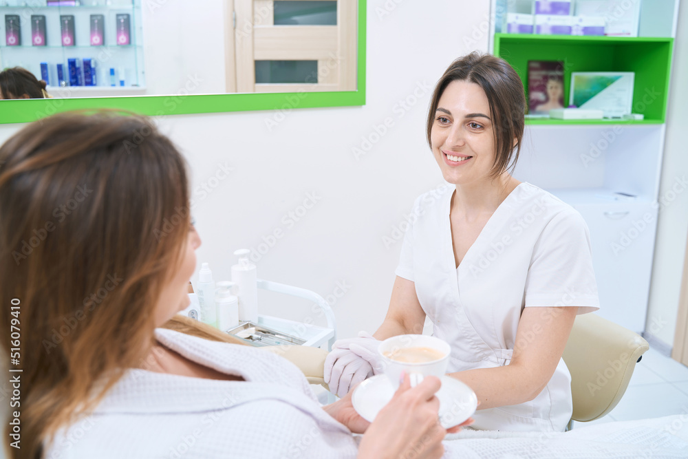 Patient of a cosmetology center is talking to a dermatologist Patient of a cosmetology center is talking to a dermatologist