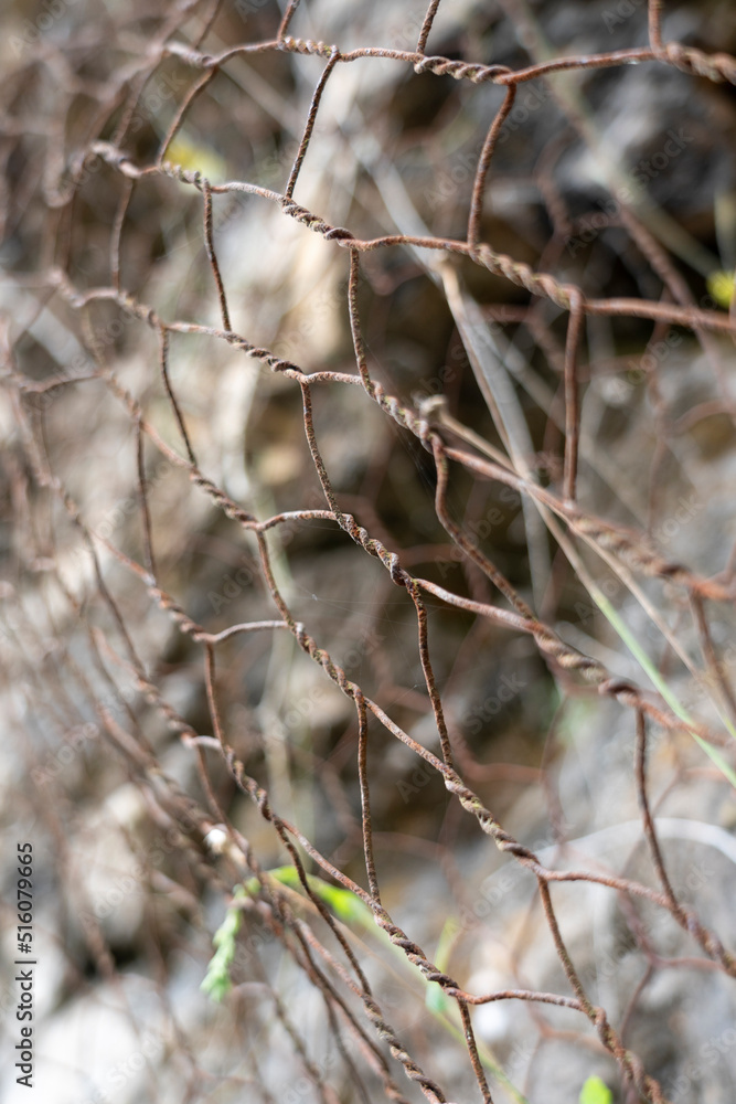 A protective metal mesh covers the rocks from rockfall A protective metal mesh covers the rocks from rockfall