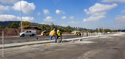 road improvement works, laying curbstones for the construction of road dividing Islands, road construction, worker's at construction site, at work, road, curb stone installation at work  photo