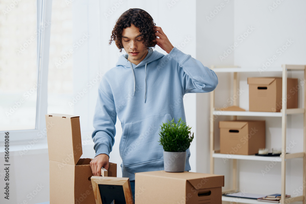 handsome guy cardboard boxes in the room unpacking in headphones Lifestyle handsome guy cardboard boxes in the room unpacking in headphones Lifestyle