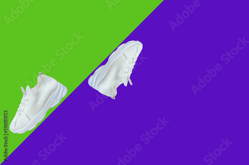  Unisex sports or city shoes demi-season sports shoes in white, highlighted on a purple and green background © Galina