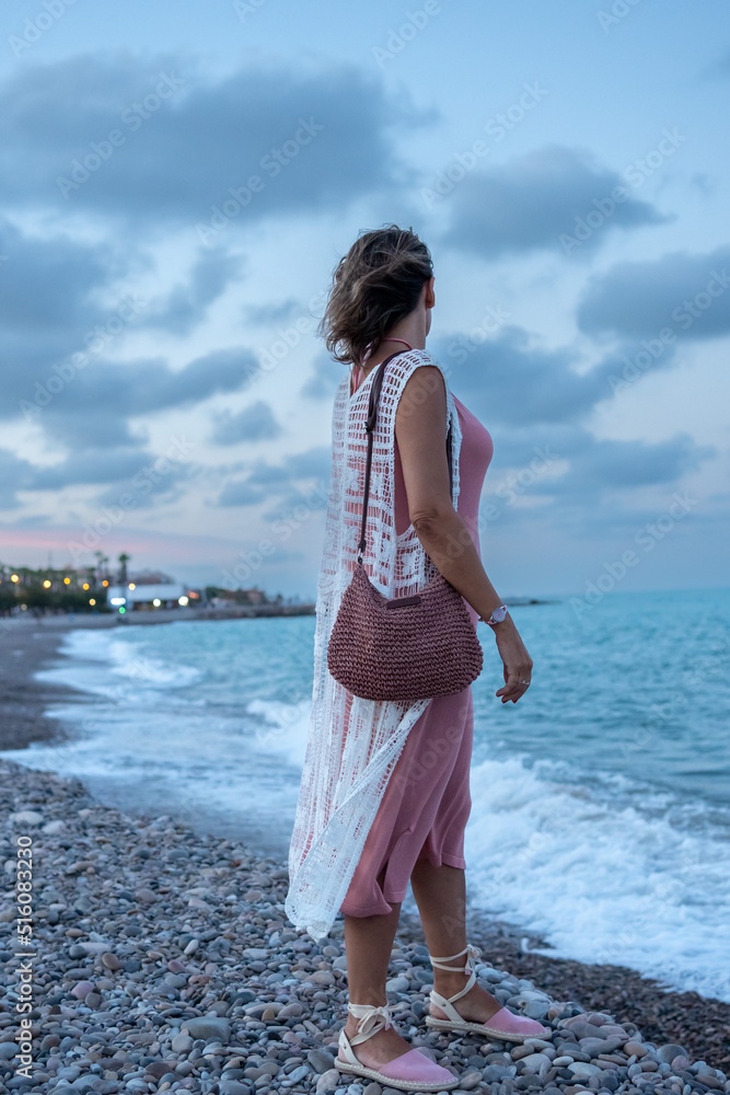Mujer mirando el horizonte disfrutauna tarde en la playa Mujer mirando el horizonte disfrutauna tarde en la playa