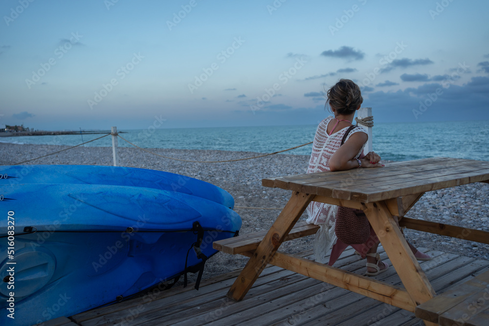 Mujer mirando el horizonte disfrutauna tarde en la playa Mujer mirando el horizonte disfrutauna tarde en la playa