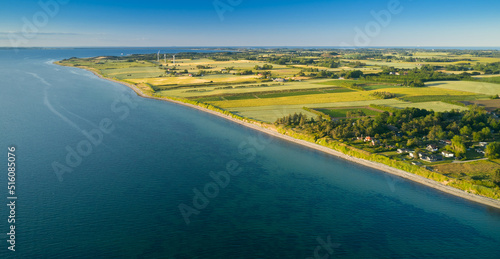 Blick von oben auf die Ostküste und den Strand der dänischen Ostsee Insel Samsø vor blauem Himmel in Richtung Süden
