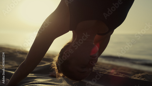 Yoga woman standing downward facing dog practicing svanasana at sunset close up. photo