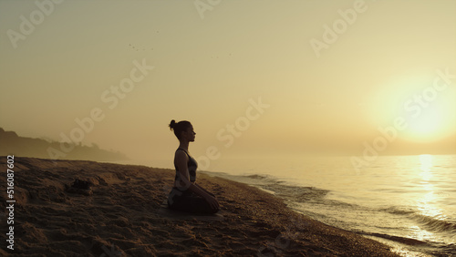 Yoga woman practicing meditation on sandy beach.Lady relaxing on nature.
