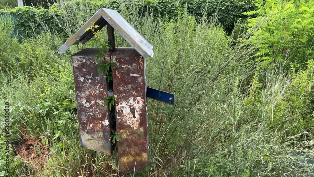 Old rusty abandoned mailbox on the street among thickets in the Chernobyl exclusion zone