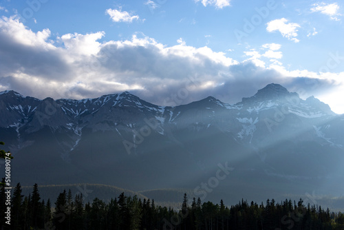 sunbeams coming through clouds in front of mountains