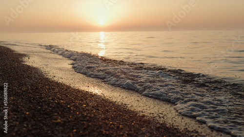 Picturesque view bright sunset on sandy beach. Soft sunlight illuminate ocean.