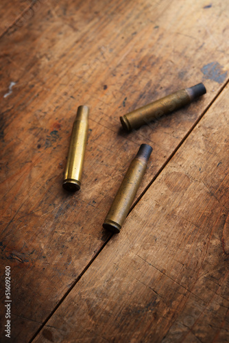 Used or spent fire arm bullet cartridges on a old wooden floor.