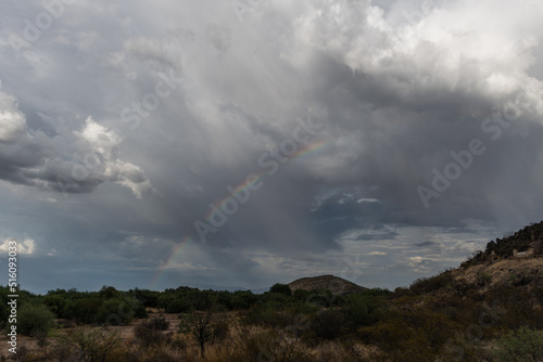 Dramatic sky and rainbow in Tucson, Arizona, near Mission San Xavier del Bac during monsoonal rainstorm