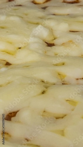 Melting pizza cheese vertical close up time lapse video.