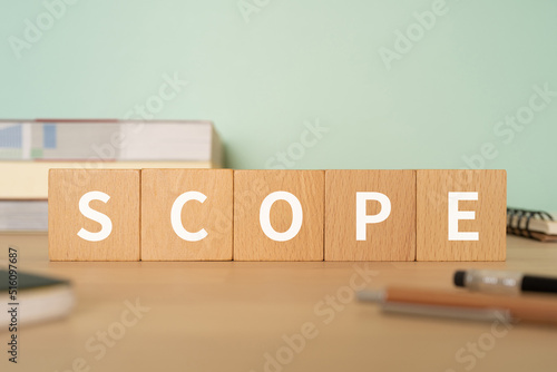 スコープ・範囲のイメージ｜「SCOPE」と書かれたブロックが置かれたデスク
 photo