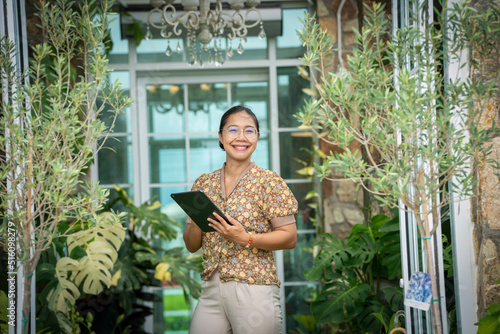 Woman working sell shipping monstera deliciosa giant plants online, woman checking plant Garden in Green house barden, air purify with Monstera,philodendron selloum, Aroid palm,Zamioculcas zamifolia photo