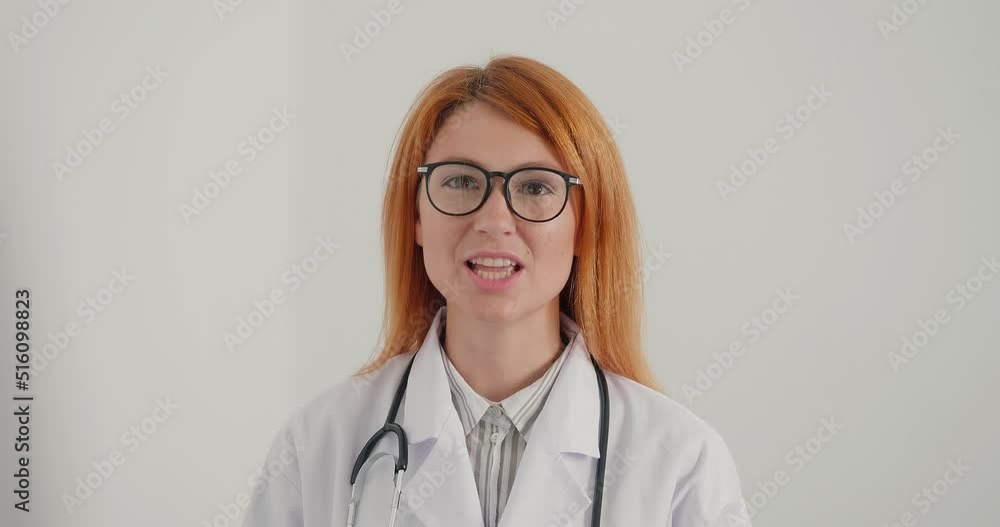 Woman doctor with glasses smiles and gives advice looking at camera Woman doctor with glasses smiles and gives advice looking at camera