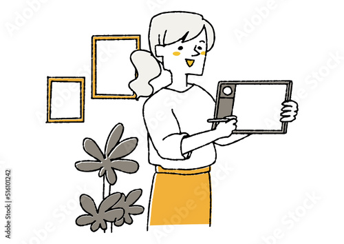 タブレットを見せながらプレゼンする女性　パソコンを使いクリエイティブな仕事をする人