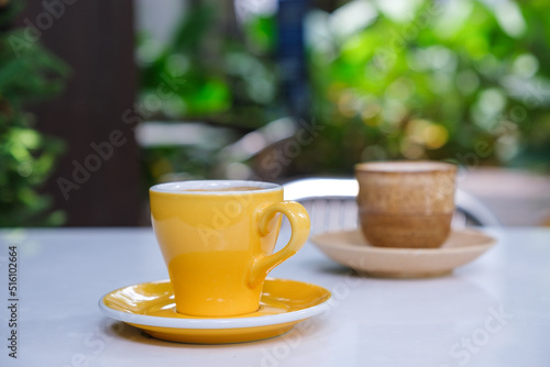 Two cups of hot coffee on the table with blur nature background