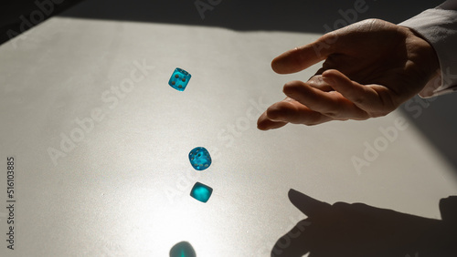 Woman throws a pair of blue transparent dice. 