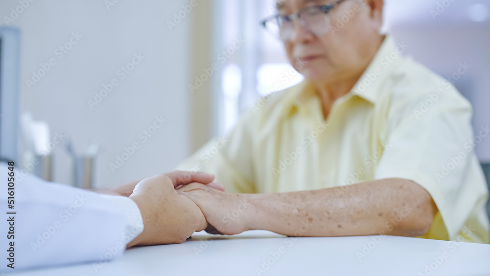 Hand of doctor comforting patient at consulting room. Doctor and patient are discussing consultation about symptom problem diagnosis of disease Hand of doctor comforting patient at consulting room. Doctor and patient are discussing consultation about symptom problem diagnosis of disease