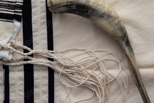 A shofar made from a lamb's horn placed on a tallit - the Jewish holiday of Rosh Hashanah photo